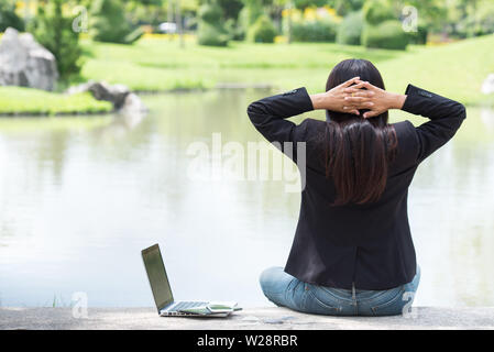 Serious Business Frau hart arbeiten mit ernsten Problem in einem öffentlichen Park. Arbeiten am Laptop im Freien. Zugeschnittenes Bild der weiblichen Arbeiten am Laptop, während si Stockfoto