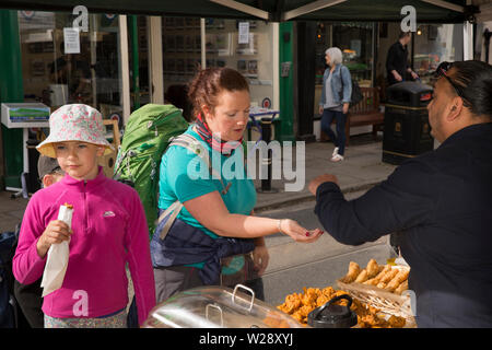 UK, Cumbria, Sedbergh, Main Street, Markt die monatlichen artizan, Frau und Kind kaufen indisches Essen zum Mitnehmen von straßenkontrollen Abschaltdruck Stockfoto