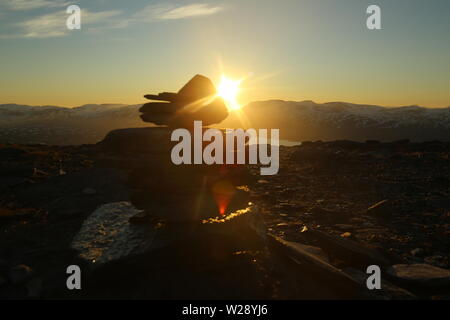 Midnight Sun von der Spitze des Nuolja in Nordschweden gesehen, mit Defokussierten Cairn. Stockfoto