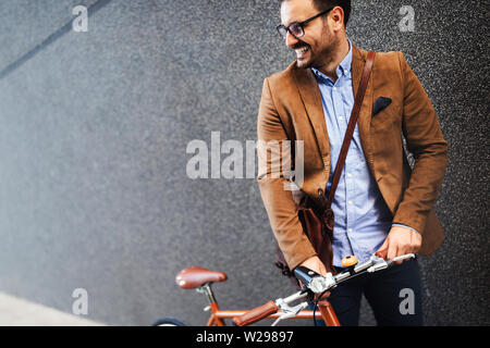 Geschäftsmann mit Fahrrad auf Urban Street in der Stadt zu arbeiten. Transport und gesunden Lebensstil Konzept Stockfoto