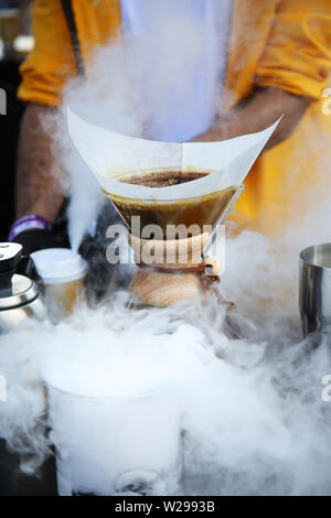 Blühende Kaffee in Papierfilter. Kaffee blühen in den Papierfilter. Kaffee mit einem chemex. Über dritte Welle Kaffee Gießen. Stockfoto