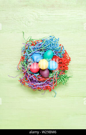 Bild der bunten Ostereier im grünen Holz- Hintergrund Stockfoto