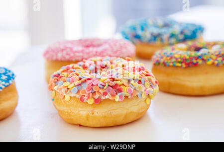 Donuts Sortiment. Pastellfarben Dekoration Donuts auf weißer Tisch. Detailansicht Stockfoto