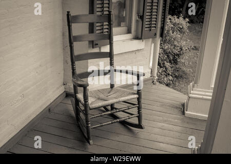 Leere Schaukelstuhl. Leere Schaukelstuhl auf der Veranda des Hauses im Retro-Stil Stockfoto