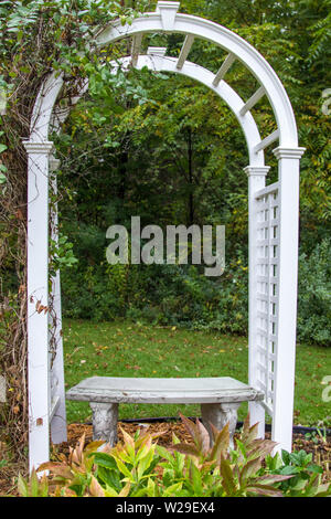 Garden Arbor und Sitzbank im Herbst. Weißes Holz Garten arch und Sitz in vertikaler Ausrichtung Stockfoto