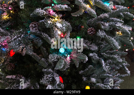 Festliche Hintergrund. Weihnachtsbaum mit Ornamenten verziert und mit bunten Lichtern in Panoramablick Orientierung beleuchtet Stockfoto