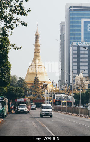 Yangon, Myanmar - März 2019: Weg zur Sule Pagode, die mit dem Verkehr auf den Vordergrund. Vertikale Ausrichtung Stockfoto