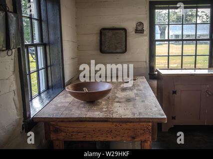 Land Küche Interieur. Rustikale Küche mit hölzernen Löffel und Schüssel auf antiken Holztisch mit einer Wäscheleine in der Ecke Stockfoto