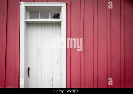 Rote Scheune an der Außenseite. Von außen eine alte Scheune aus rotem Holz Wand mit Seitentür und kopieren die Räume in horizontale Ausrichtung. Stockfoto