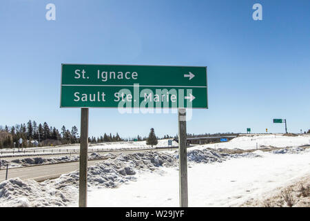 Der oberen Halbinsel von Michigan Winter. Die Autobahn 75 Zeichen für die Städte St. Ignace und Sault Ste Marie 23.38.39 in der von Michigan an einem sonnigen Wintertag Stockfoto