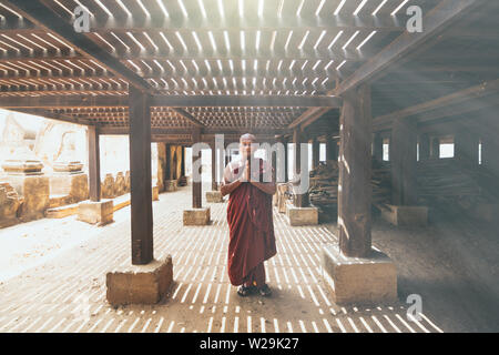 Bagan, Myanmar - März 2019: birmanischen buddhistischen Mönch in einem Kloster beten an einem sonnigen Tag Stockfoto