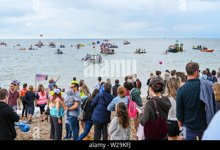 Brighton UK 7. Juli 2019 - die Wettbewerber sich auf hoher See aus Brighton Beach während dieser Jahre Paddeln Rund um die Pier Beach Festival in Brighton. Die jährlichen Paddel Rund um die Pier ist mittlerweile das größte kostenlose Beach Festival in Europa Geld für verschiedene Nächstenliebe einschließlich Surfers gegen Abwasser. Foto: Simon Dack/Alamy leben Nachrichten Stockfoto