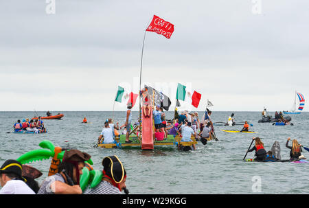 Brighton UK 7. Juli 2019 - die Wettbewerber sich auf hoher See aus Brighton Beach während dieser Jahre Paddeln Rund um die Pier Beach Festival in Brighton. Die jährlichen Paddel Rund um die Pier ist mittlerweile das größte kostenlose Beach Festival in Europa Geld für verschiedene Nächstenliebe einschließlich Surfers gegen Abwasser. Foto: Simon Dack/Alamy leben Nachrichten Stockfoto