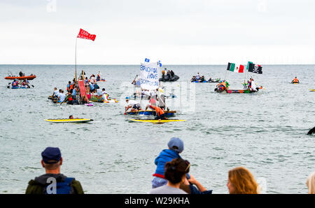 Brighton UK 7. Juli 2019 - die Wettbewerber sich auf hoher See aus Brighton Beach während dieser Jahre Paddeln Rund um die Pier Beach Festival in Brighton. Die jährlichen Paddel Rund um die Pier ist mittlerweile das größte kostenlose Beach Festival in Europa Geld für verschiedene Nächstenliebe einschließlich Surfers gegen Abwasser. Foto: Simon Dack/Alamy leben Nachrichten Stockfoto