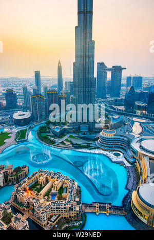 Dubai, Vereinigte Arabische Emirate - Juli 5, 2019: Burj Khalifa steigen über Dubai Mall und Brunnen durch die moderne Innenstadt von Gebäuden umgeben, oben Stockfoto