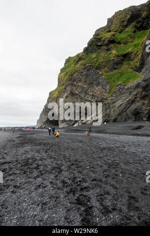 Blick entlang Reynisfjara schwarzen Sand Strand in Richtung sechseckigen Basaltsäulen, südlichen Island. Stockfoto