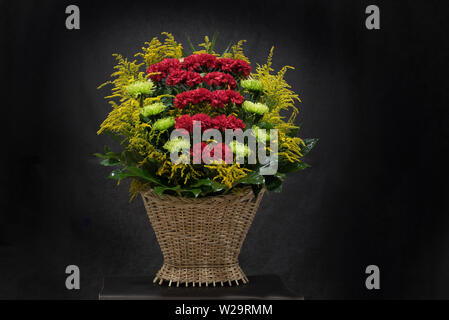 Rituelle Begräbnis Korb mit Blumen auf schwarzem Hintergrund. Die Blume Anordnung der Blumen im Korb ist für Begräbnisse und Lesezeichen verwendet. Mourni Stockfoto