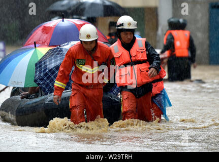 Fujian, China. 07 Juli, 2019. Feuerwehrmänner retten Bewohner in der Flut verursacht durch eine Reihe von intensiven Regenfällen in das Grafschaft Sanming gefangen im Südosten der chinesischen Provinz Fujian, 7. Juli 2019. Quelle: Xinhua/Alamy leben Nachrichten Stockfoto