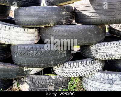 Reifen übereinander gestapelt. Große Stapel von Reifen dump. Illegale Müllkippe. Das Konzept der Ökologie Umweltverschmutzung. Stockfoto