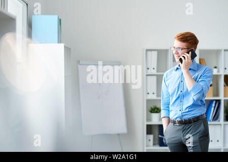 Junge zuversichtlich Geschäftsmann sprechen auf dem Smartphone Stockfoto