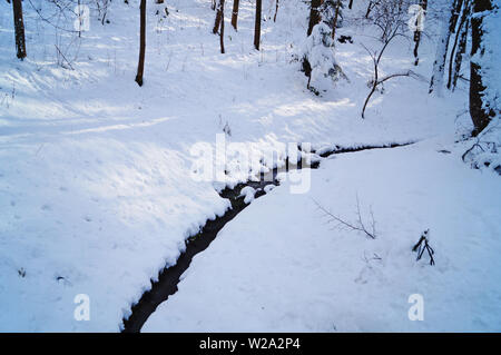 Die Mountain River fließt zwischen den Kufen mit Schnee an einem Wintertag abgedeckt Stockfoto