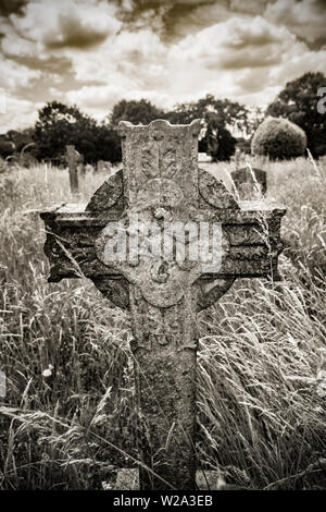 Ein steinernes Kreuz Grabstein in Gillingham Friedhof Dorset. Schwarz und Weiß sepia digitales Foto. Dorset England UK GB Stockfoto
