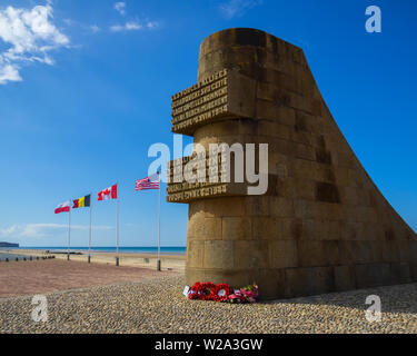 Weltkrieg zwei D-Day Memorial Denkmal Signal am Omaha Beach mit Flaggen im Hintergrund, Saint-Laurent-sur-Mer, Normandie, Frankreich. Stockfoto