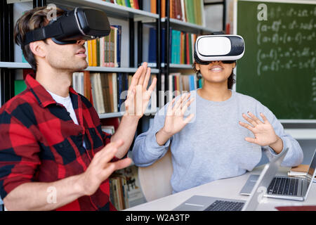 Junge erstaunt der Mann und die Frau in der VR-Headsets in virtuelle Erfahrung Stockfoto