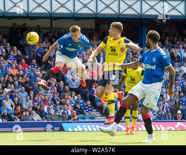 Der Oxford Josh Ruffels Herausforderungen Förster Lewis Mayo, die Köpfe für Ziel die gespeichert war, aber er die Rechnung über die Torlinie für das dritte Ziel Förster gezwungen, während der Vorsaison freundlich an Ibrox Stadium, Glasgow. Stockfoto