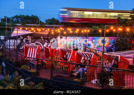 Junge Leute im Else Bar Club, Zug, S-Bahn fährt herum, Dämmerung, Alt Treptow, Berlin City Life Deutschland, Leute sitzen in Korbliegen Stockfoto