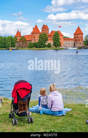 Mutter und Sohn auf dem Gras an der mittelalterlichen Burg von Trakai, Vilnius, Litauen, Osteuropa, zwischen den wunderschönen Seen und Natur suchen, Stockfoto