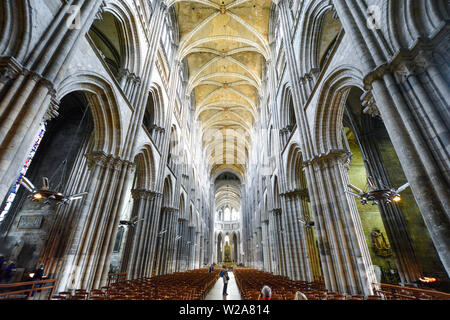 Touristen nehmen Fotos und sitzen in den Kirchenbänken und Langhaus der Kathedrale von Rouen, Frankreich Stockfoto