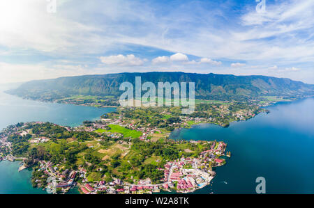 Antenne: Toba-See und die Insel Samosir Blick von oben Sumatra Indonesien. Riesige vulkanische Caldera von Wasser bedeckt, traditionelle Batak Dörfer, grüne Reis Stockfoto