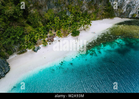 Antenne drone Ansicht der verlassenen Haus Hütte auf Pinagbuyutan Insel in El Nido. Super White Sand Beach und Emerald Lagoon Water Stockfoto