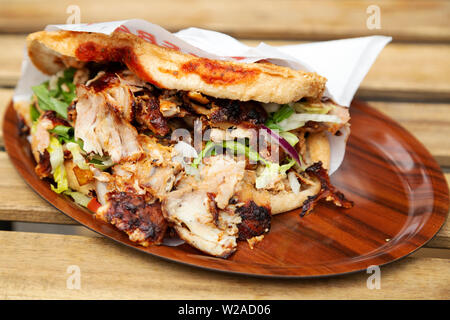 Ein Lamm Döner Kebab serviert in Berlin, Deutschland. Die Kebab ist in einem Brot Brötchen mit Salat und einer würzigen Sauce serviert. Stockfoto