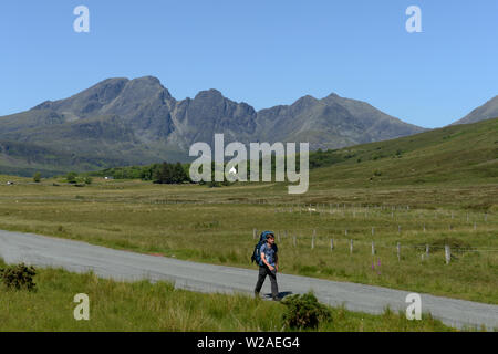 Zurück packer zu Fuß Straße nach Elgol mit Blà Bheinn oder blaven Berg auf der Isle of Skye in Schottland und seine unverwechselbare zerklüfteten felsigen Umrisse sichtbar. Stockfoto