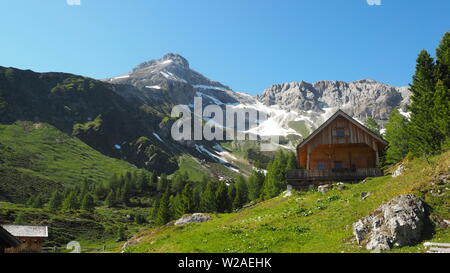 Panoramablick auf den idyllischen Bergkuppen, Mosermandl, und traditionelle Berghütte in den Alpen an einem sonnigen Tag mit blauen Himmel, in der Nähe der Jakoberalm in Rads Stockfoto