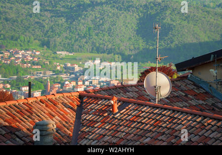Antenne und Satellitenschüssel auf dem Dach des Hauses. Stockfoto