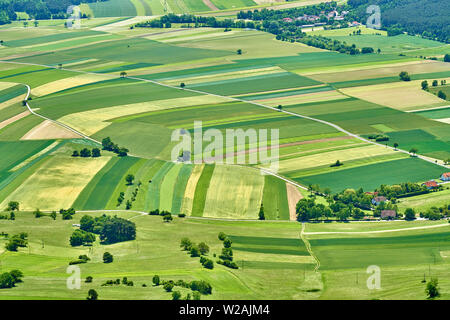 Felder, Wälder und Straßen, Gebäude, schöne Muster. Weizen ist noch nicht reif, also viel grüne Farbe. Wie von der Hohen Wand, Österreich gesehen. Stockfoto