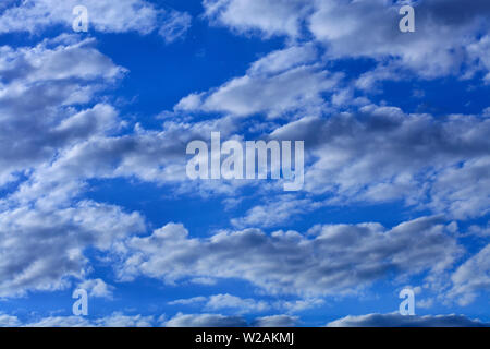 Blauer Himmel mit weißen und grauen kondensierend Fluffy Clouds. Stockfoto