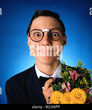 Junger Mann dress up Brille mit Blumen, die wie ein Nerd trägt eine Fliege ist hier glatt zurück Barry schwarz Stockfoto