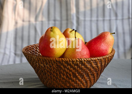 Nahaufnahme von roten und gelben Birnen in Korb Stockfoto