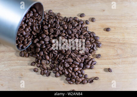 Kaffee Bohnen Verschütten aus einem rohrförmigen Metallbehälter Stockfoto