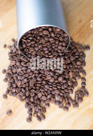 Kaffee Bohnen Verschütten aus einem rohrförmigen Metallbehälter Stockfoto