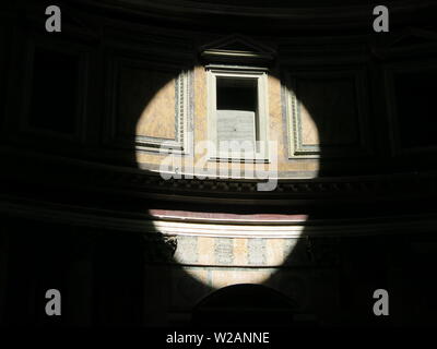 Die Wirkung von Sonnenlicht durch die offenen Kuppel im Pantheon kommen einen hellen Kreis an der Wand in den umliegenden Dunkelheit zu erstellen Stockfoto