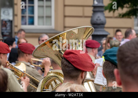 Trompeter, die sich an der Fronleichnamsprozession auf dem Marktplatz von Krakau Altstadt, Polen. Die Gebäude sind in Trompete wider. Stockfoto