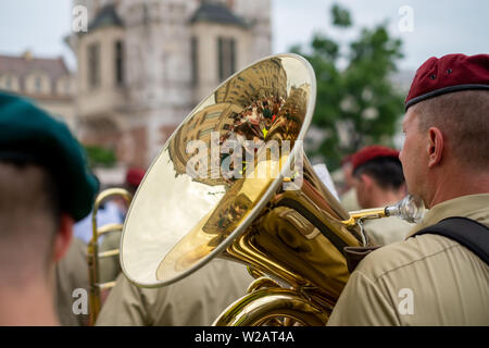 Trompeter, die sich an der Fronleichnamsprozession auf dem Marktplatz von Krakau Altstadt, Polen. Die Gebäude sind in Trompete wider. Stockfoto