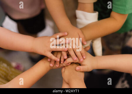 Kinder die Hände übereinander. Kinder- Team und unter den kleinen Kerlen. Stockfoto