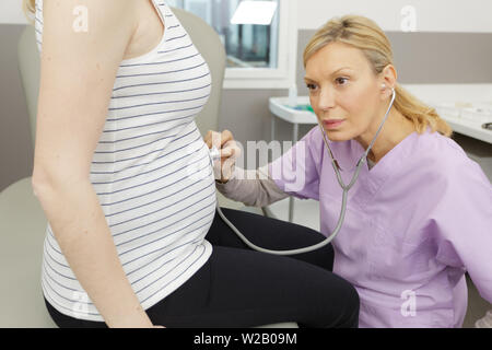 Frauenarzt hören mit Stethoskop zu stoßen Stockfoto