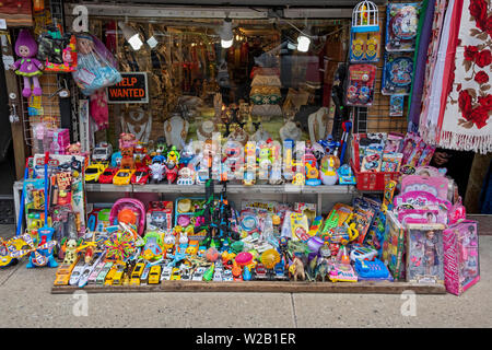 Einem sehr gedrängten Darstellung der ist billig Kinderspielzeug für den Verkauf außerhalb einen Sari shop auf 74th Street in Jackson Heights, Queens, New York City. Stockfoto